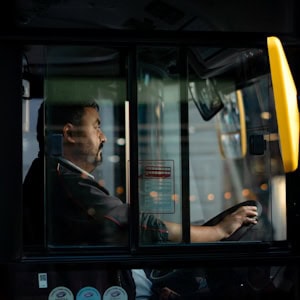 Bilde av en bussjåfør som kjører en turistbuss, med fokus på sikkerhet og komfort, i tråd med Stord Turbuss sin tjenesteprofil.
